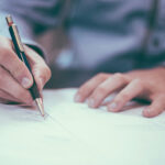 Visuel du cas client Groupe Audeo représentant une main tenant un stylo